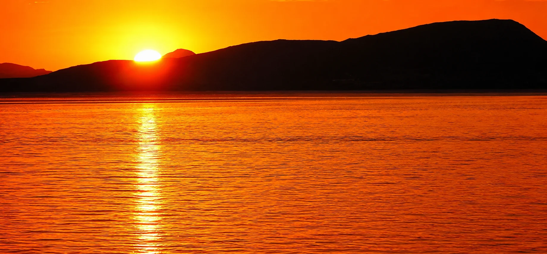 Sunset over a calm ocean horizon